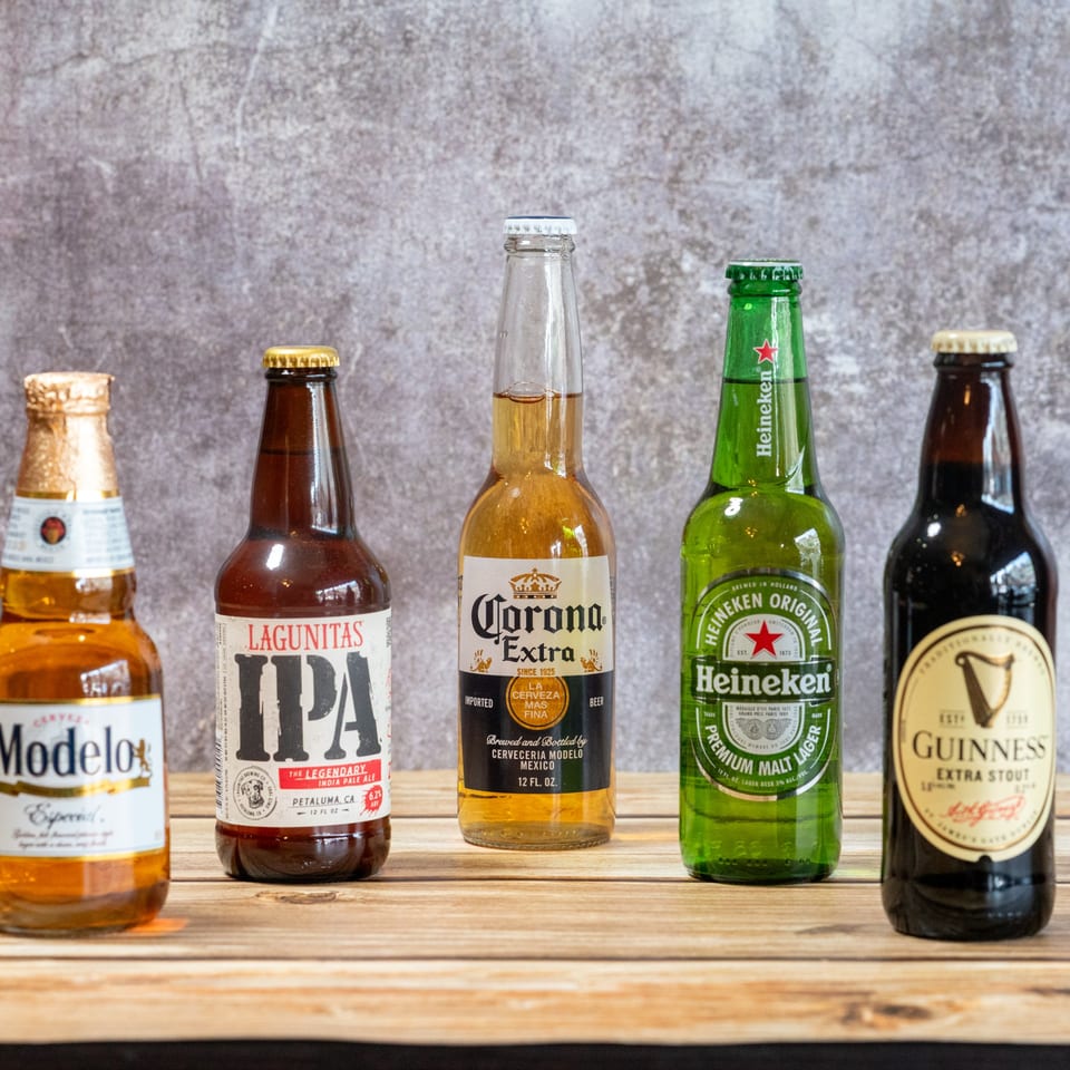 Five bottles of beer, including Modelo, Lagunitas IPA, Corona Extra, Heineken, and Guinness Extra Stout.
